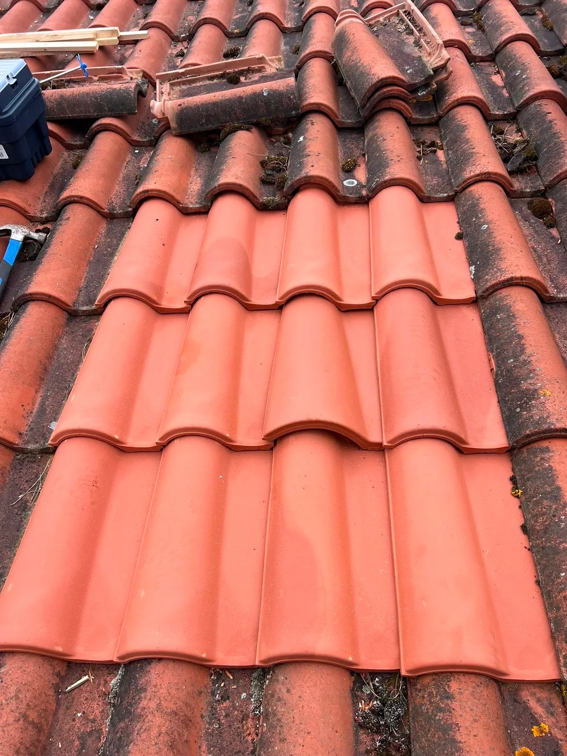 Détail du remplacement de tuiles neuves sur une toiture ancienne, Gers