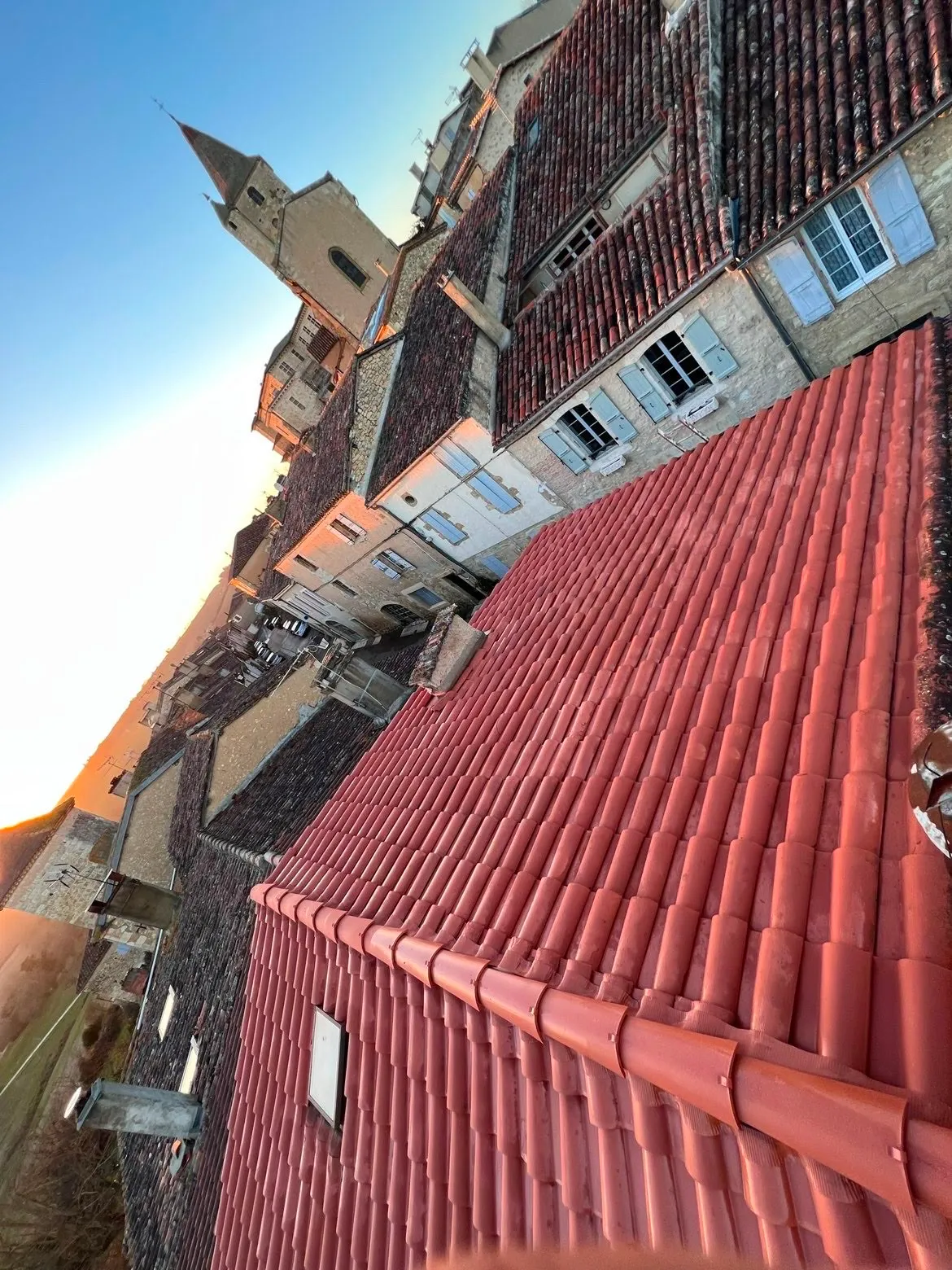 Toiture en tuile canal neuve au coucher de soleil dans un village gascon